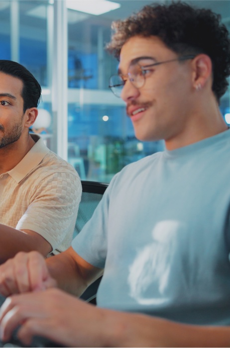 Two colleagues at an AI company collaborating on their computers, supported by Pebl’s EOR for AI solution