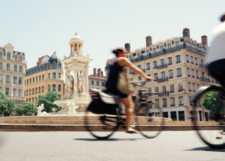 Woman biking next to the Fontaine des Jacobins in Lyon, France
