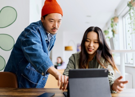 Two remote employees working together from a co-working space in Asia.