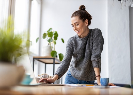 Female employee using her laptop standing up