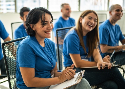 Nonprofit leaders in matching blue uniforms sit down for a team meeting.
