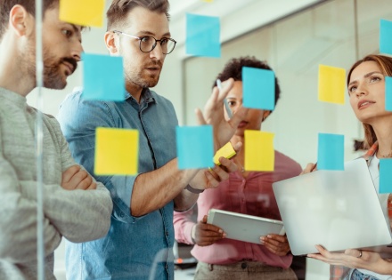 Four people visualizing hybrid work models with post-it notes