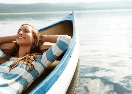 Woman enjoying her paid vacation days relaxing in a canoe
