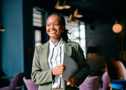 Smiling businesswoman in Cameroon holding a laptop