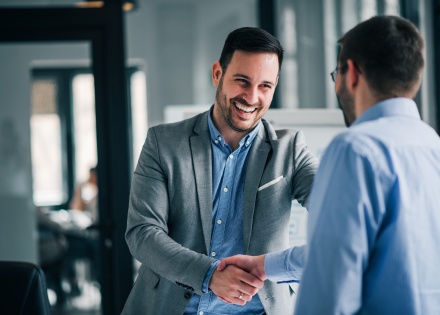 Cheerful young manager shaking hands with new employee in Benin