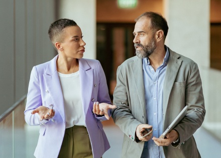 Business partners walking in an office building and discussing payroll taxes in Georgia