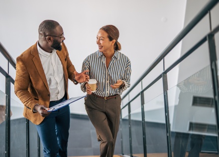 Colleagues in Brazil walking and talking downstairs in an office building