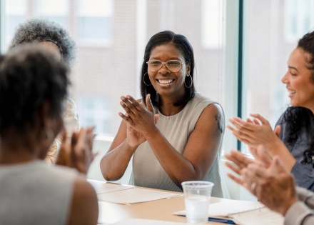 Group of employees smiling and clapping while celebrating workplace culture in Fiji