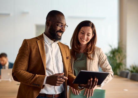 Smiling business people using a digital tablet in an office in Brunei