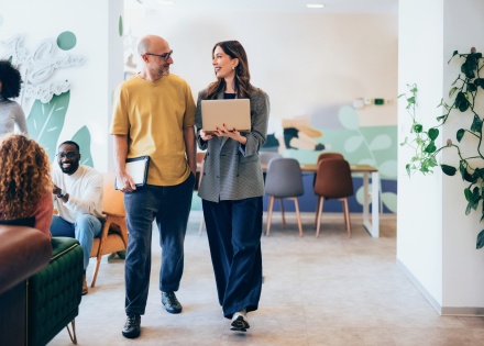 Two professionals discussing work in a modern office in Macedonia