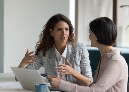 Two businesswomen discussing payroll taxes in Denmark