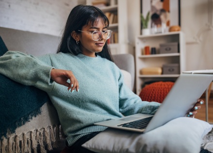 Woman relaxing with laptop in modern home in Burkina Faso