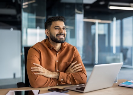 Businessman smiling and sitting at an office desk in Jordan