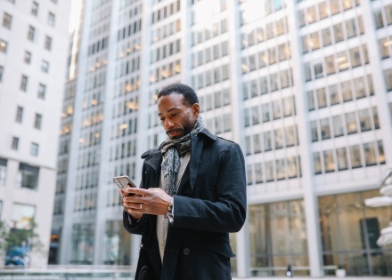 Businessman in Chile walking outdoors looking at his phone