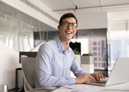 Smiling man in glasses typing on laptop in the Czech Republic