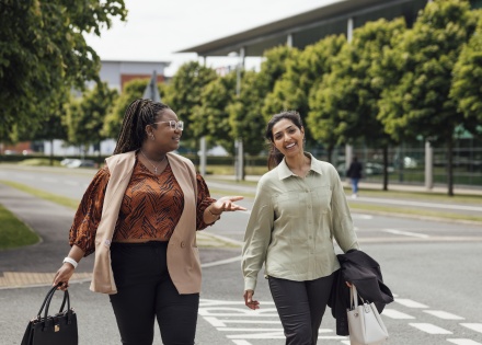 Two businesswomen walking and talking about salary in Kazakhstan