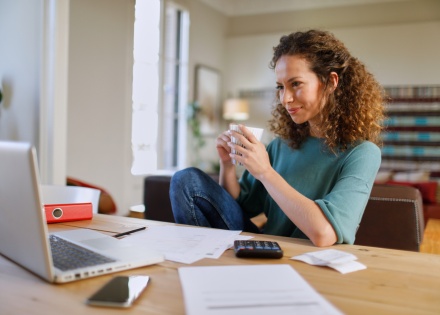 Woman in her home office holding a cup of coffee