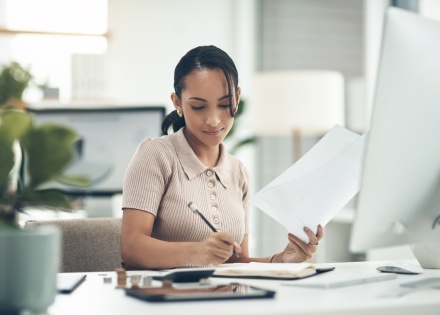 Young businesswoman calculating payroll taxes in Bahrain