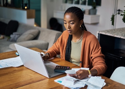 Young woman working from home and calculating payroll taxes in Ethiopia