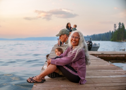 Cheerful woman sitting on a lakeside dock at sunset in Cameroon