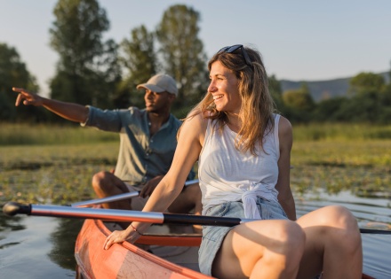 Couple canoeing on calm lake at sunset in Slovakia
