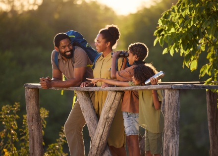 Happy family of hikers on a viewpoint at sunset during a Congo public holiday