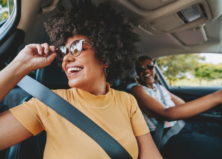 Happy friends traveling by car during a Ghana public holiday
