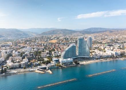 Limassol cityscape with modern architecture, coastline, and mountains