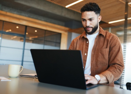 Male research analyst working on his laptop