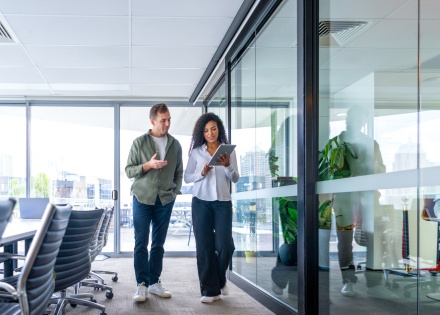 Man and woman walking and talking in an office