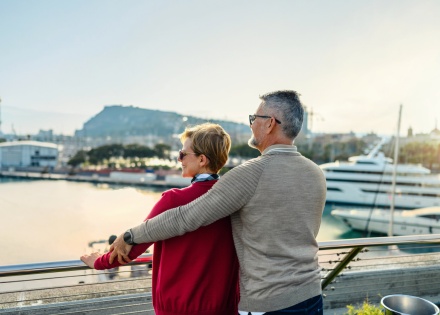 Mature couple on the terrace looking out at the harbor during a Polish public holiday