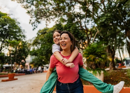 Mother giving her daughter a piggyback ride during Tanzania's public holidays