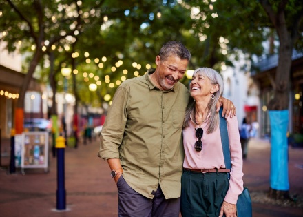 A smiling older couple walks together on a city street during a Pakistani public holiday