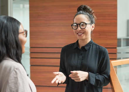 Smiling young businesswoman talking to her colleague about payroll taxes in Peru