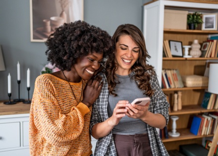 Friends in an apartment smiling at a phone during Mauritius’ public holidays