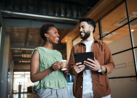 Two smiling colleagues engage in a conversation about payroll tax in Lebanon