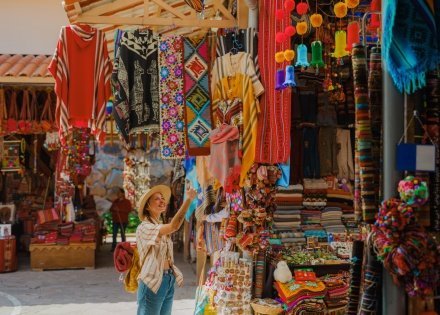 Woman photographing with smartphone on Pisac Market in Peru