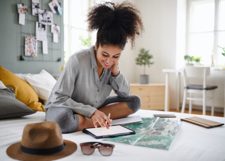 Young woman planning her Jordan public holiday at home with a map and tablet