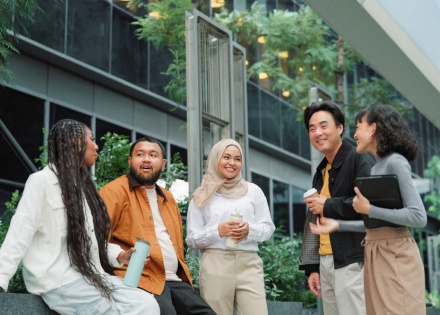 Business team talking and taking a break outside at a green office space