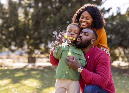 Family blowing bubbles in a park during Belize’s public holidays