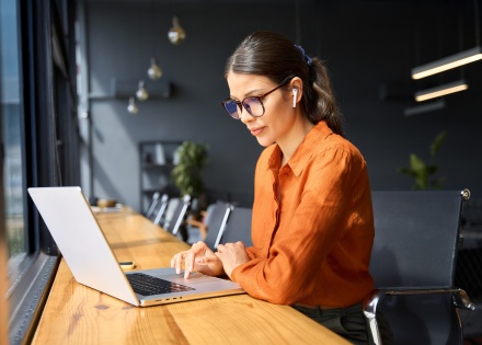 Female inventory analyst working on her laptop in an office