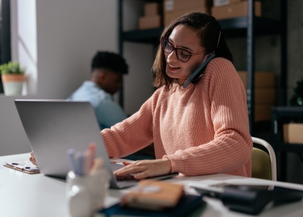 Female logistics coordinator on the phone and working on a computer