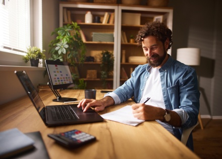 Male content strategist working from home and taking notes