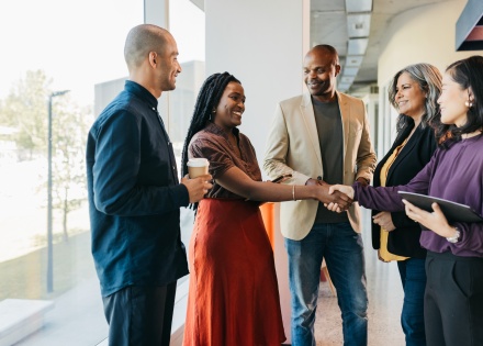Multiracial business partners shaking hands in coworking business pace