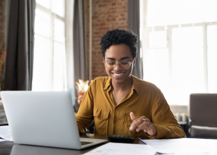 Young entrepreneur woman in glasses calculating payroll taxes in Oman