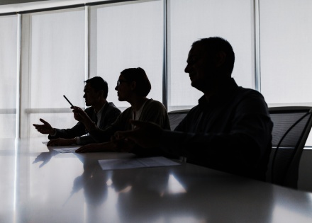 Lawyers sitting down in a meeting in dark room