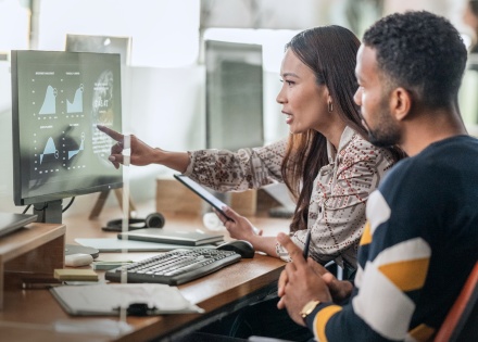 man and woman looking at computer screen