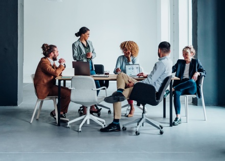 Colleagues collaborating in an office, organizing remote team-building activities.