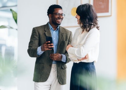 Two colleagues discussing staff augmentation during a friendly conversation in the office.