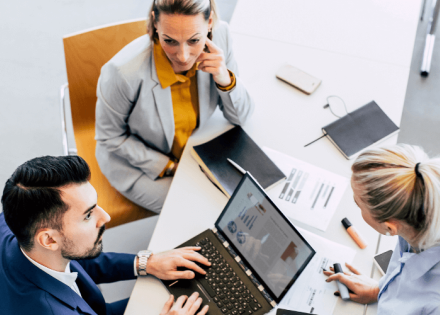 three employees working around a table